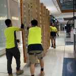 JD Movers team moving large display crate inside a Melbourne shopping centre