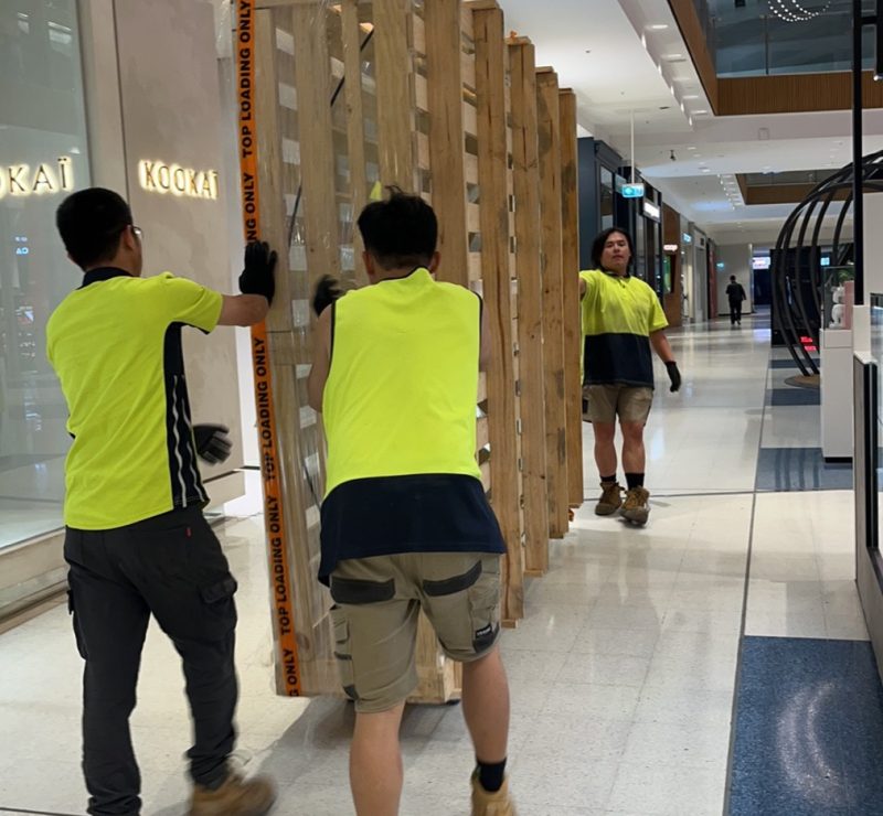 JD Movers team moving large display crate inside a Melbourne shopping centre
