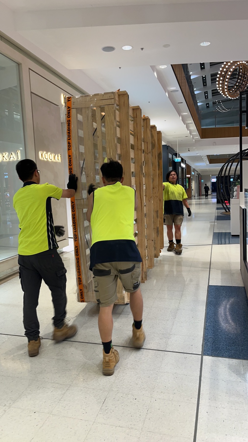 JD Movers team moving large display crate inside a Melbourne shopping centre
