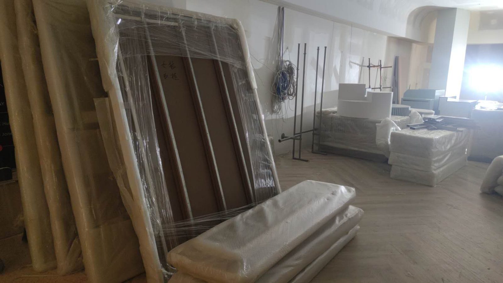 Wrapped frames, mattresses and furniture staged inside a property during a separate real JD Movers job, illustrating Cheltenham move preparation