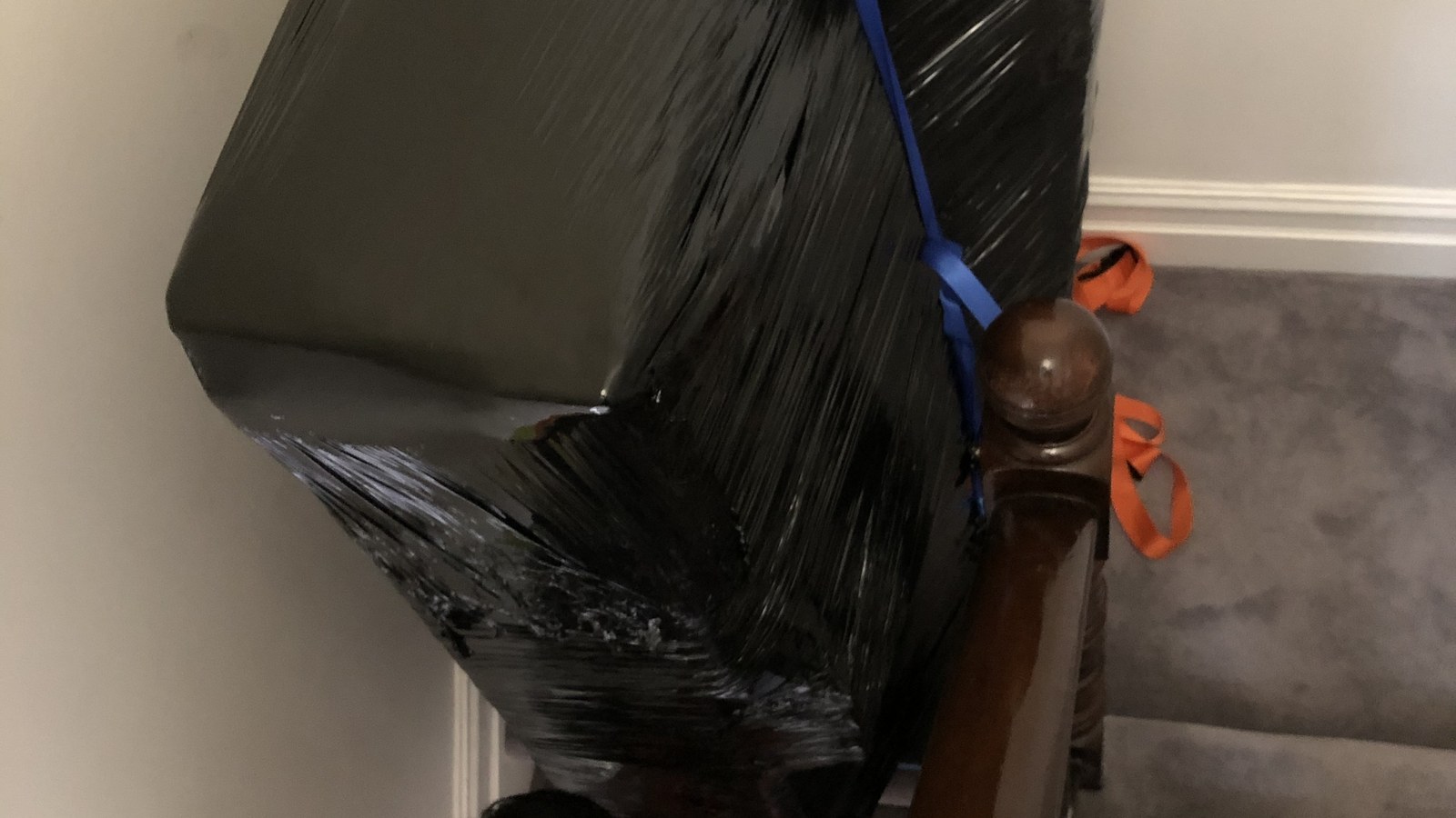 A protected heavy household item on stairs during a real JD Movers job, illustrating Kew East access planning