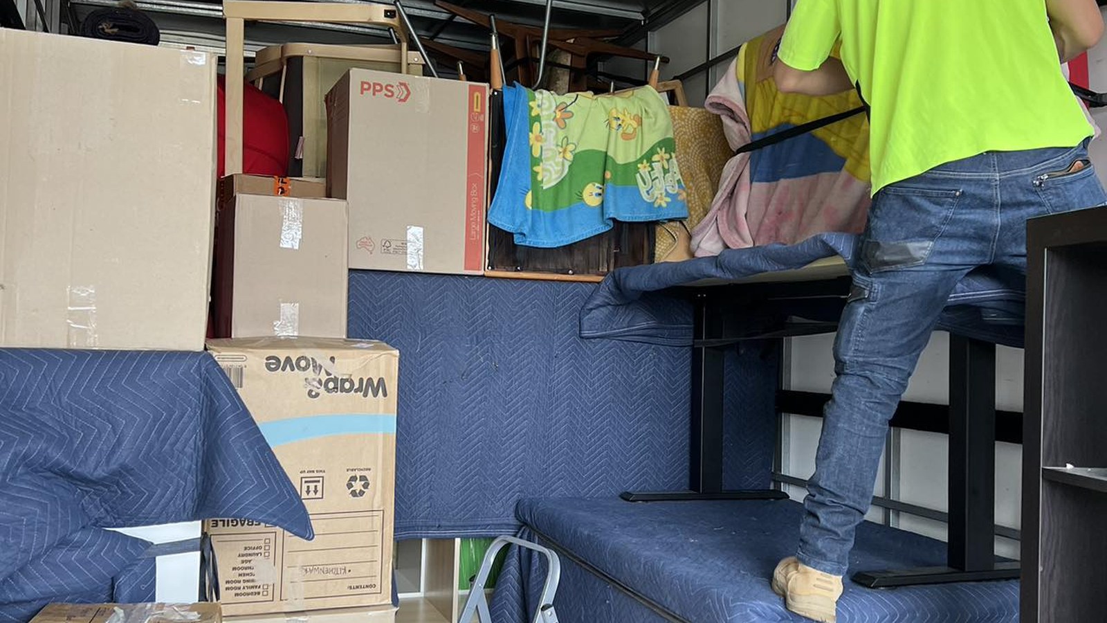 A JD Movers team member arranging furniture and cartons inside the truck during a real move