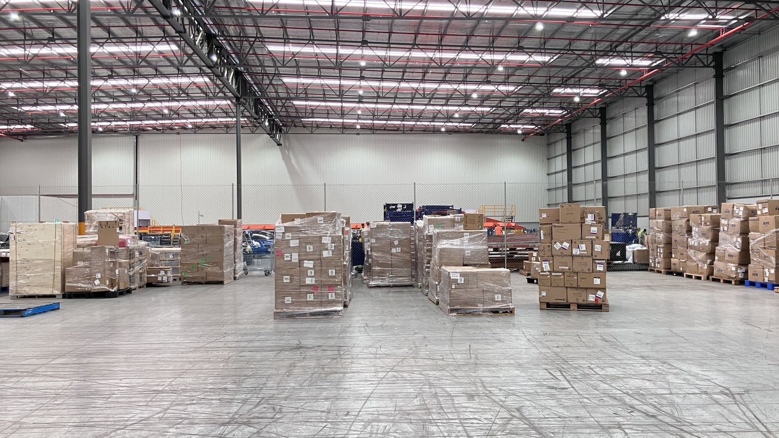 Palletised goods arranged in a warehouse during a real JD Movers commercial relocation