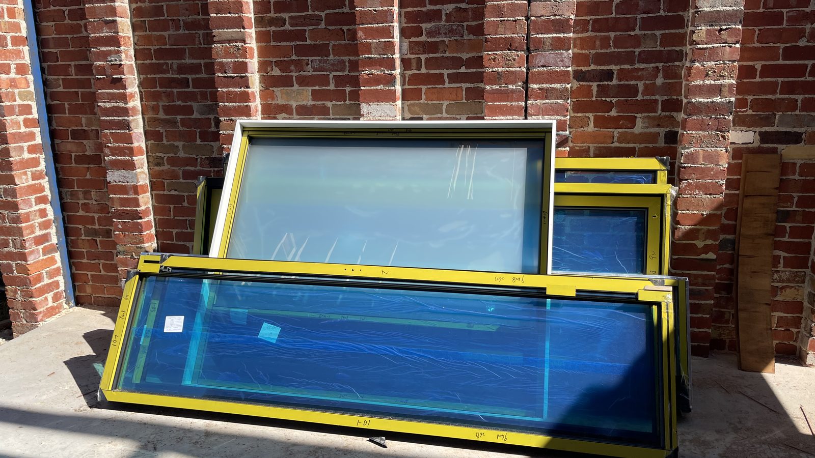 Stacked framed glass panels prepared on a clear work area in a real JD Movers job, illustrating St Albans move planning