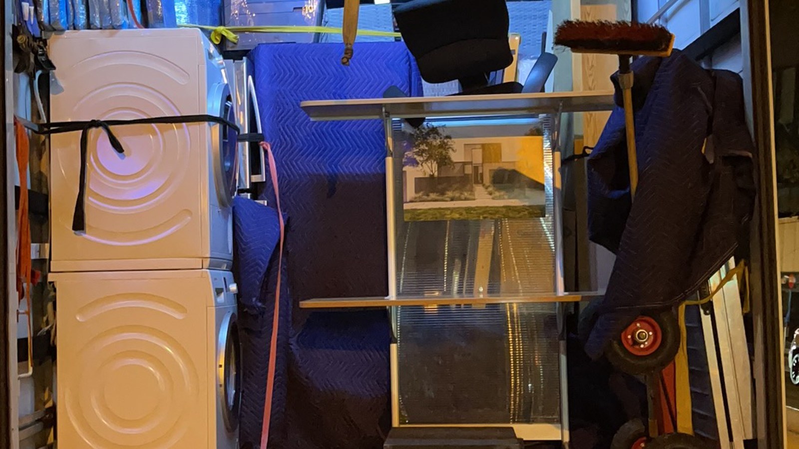 Glass display cabinet and stacked appliances secured inside a real JD Movers truck for Vermont move planning